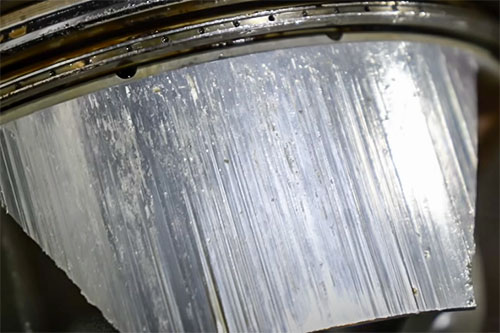 Macan V6 piston close-up with bore scoring.